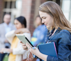 Schülerin hält ihr BYOD-Gerät in der Schule in der Hand